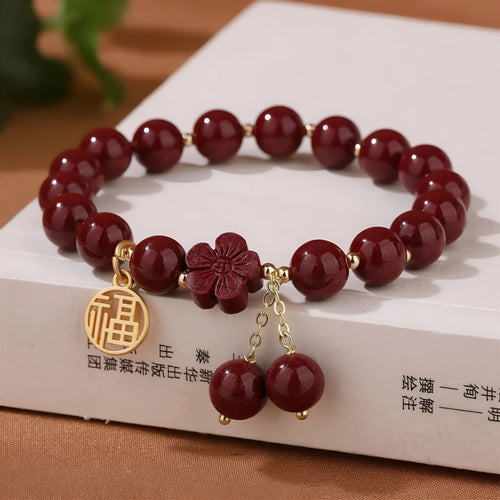 Women's cinnabar bracelet with fu character charm in purple gold sand colour and peach blossom detailing