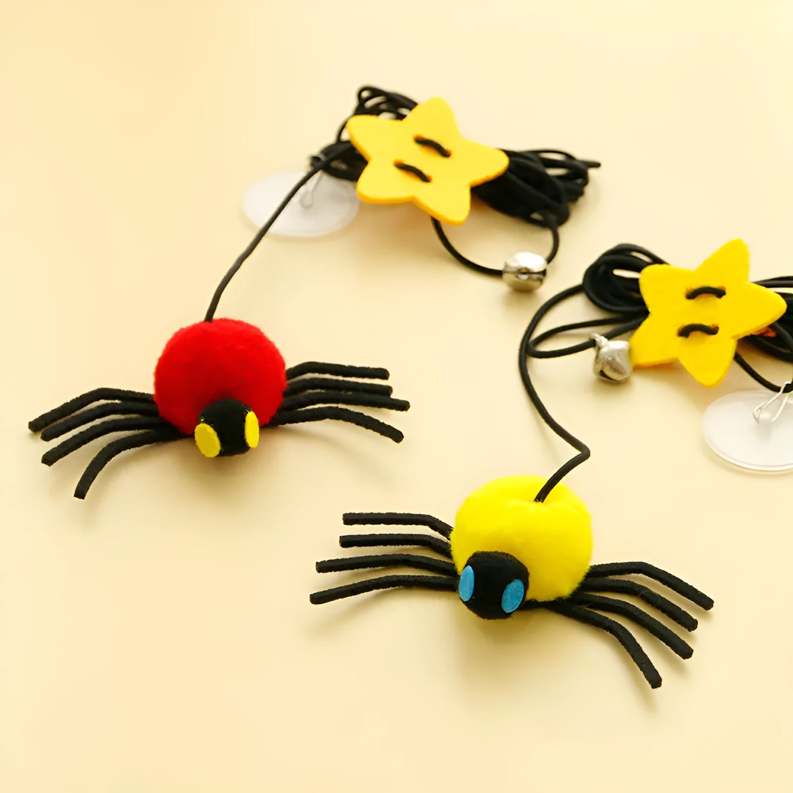 Red and yellow door-hanging cat toy with elastic rope, feather, bell and spider attachment for indoor feline play